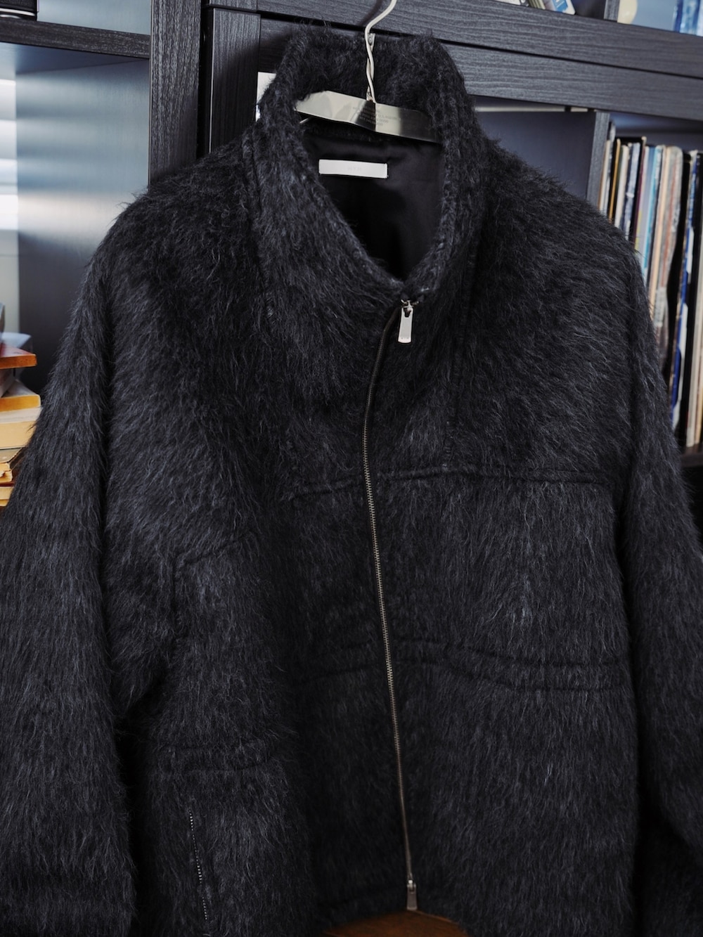 グレー系のブルゾン、ブラウン系のニット/セーター、ブラック系のデニムパンツを着用したメンズの秋コーディネートの5枚目の写真