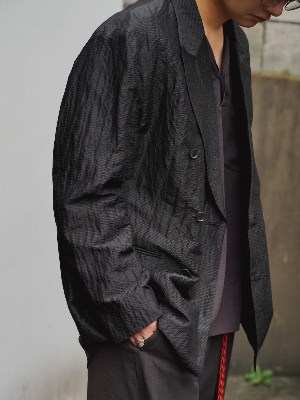 ブラック系のテーラードジャケット、ブラック系のシャツ/ブラウス、ブラウン系のスラックスを着用したメンズの夏コーディネートの5枚目の写真