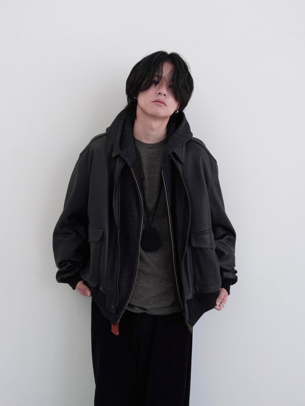 ブラック系のブルゾン、ブラック系のパーカー、イエロー系のTシャツ/カットソーを着用したメンズの秋コーディネートの4枚目の写真