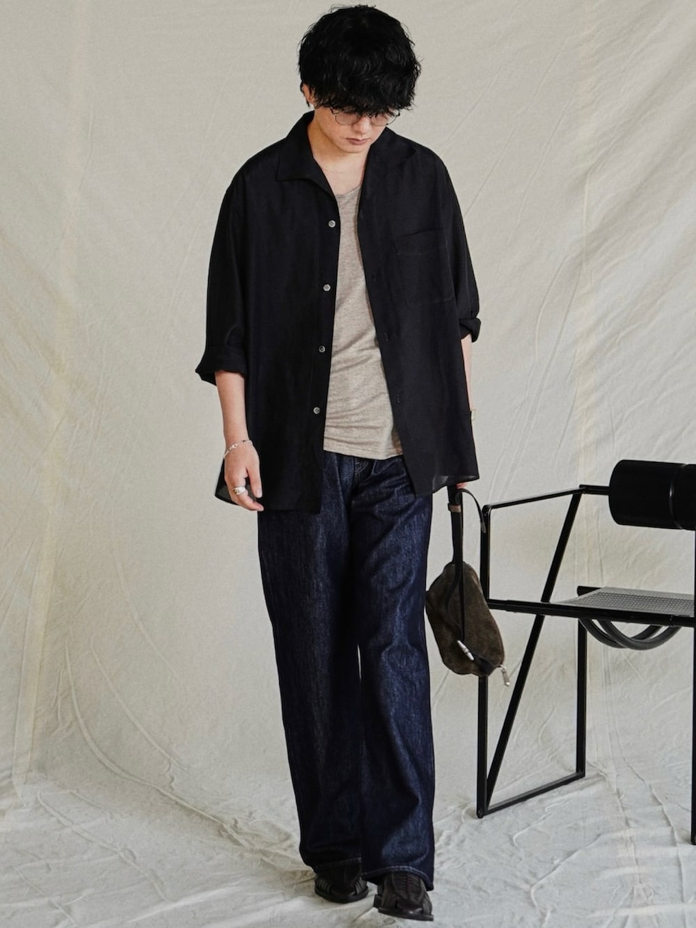 ブラック系のシャツ/ブラウス、ブルー系のデニムパンツ、シルバー系のブレスレットを着用したメンズの夏コーディネートの2枚目の写真
