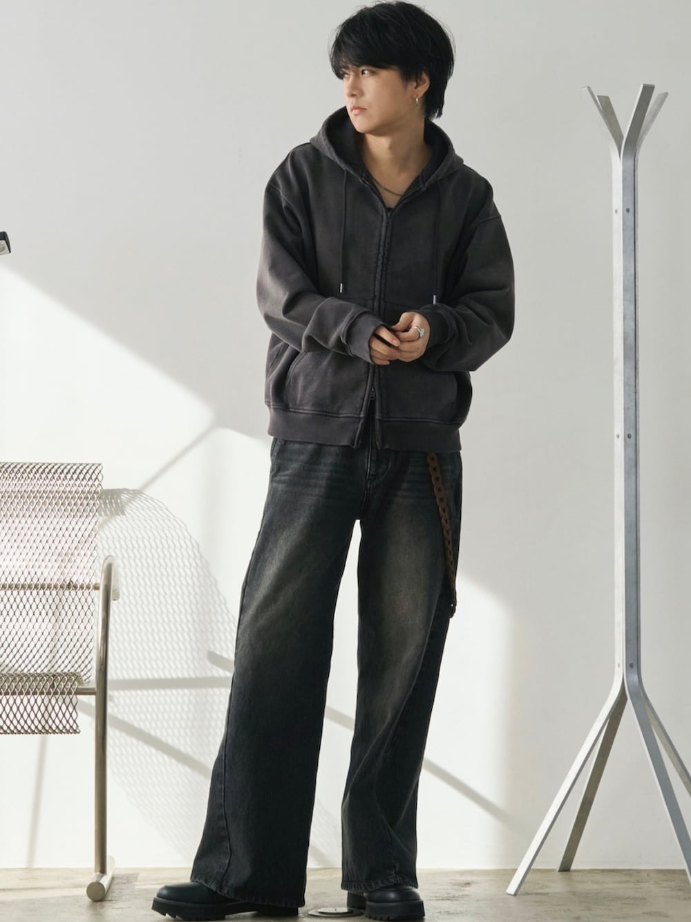 ブラウン系のパーカー、ブルー系のデニムパンツ、ブラック系のドレスシューズを着用したメンズの冬コーディネートの3枚目の写真