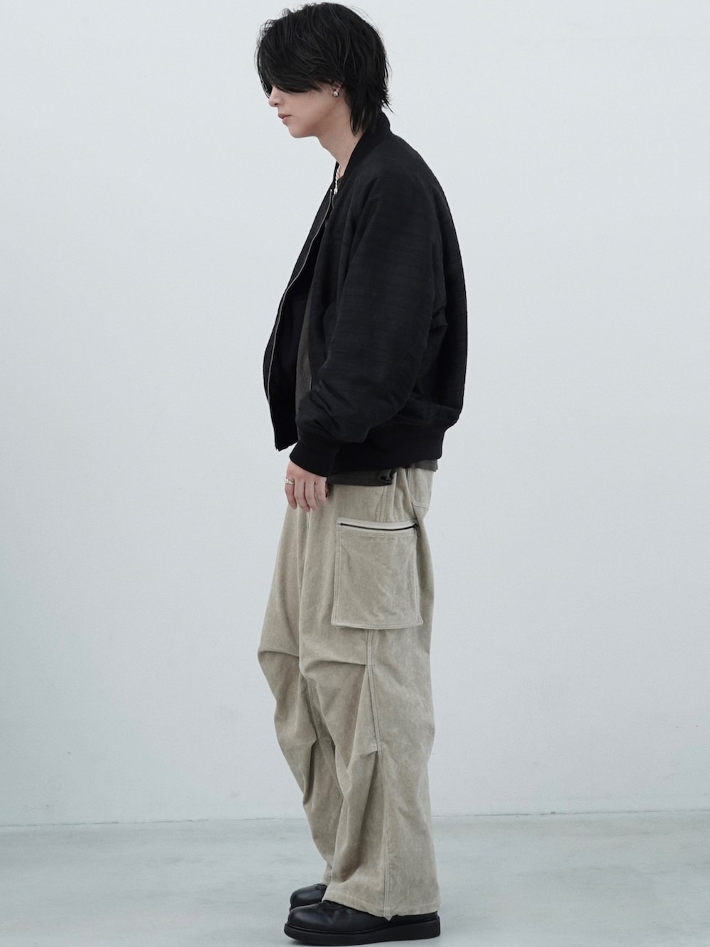 ブラック系のMA-1、ベージュ系のカーゴパンツ、イエロー系のTシャツ/カットソーを着用したメンズの夏コーディネートの2枚目の写真