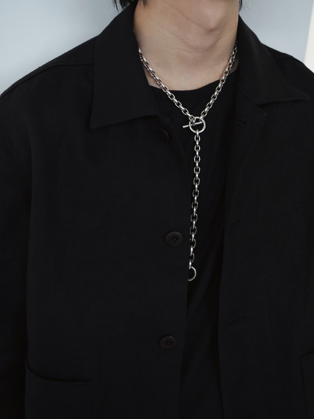 ブラック系のステンカラーコート、ブラック系のブルゾン、ブラック系のスラックスを着用したメンズの春コーディネートの4枚目の写真