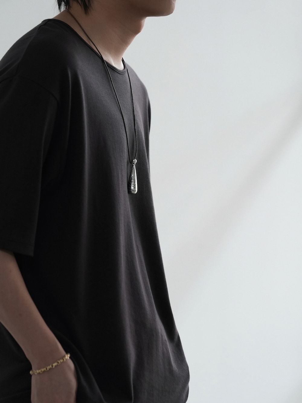 ブラック系のその他パンツ、ブラウン系のTシャツ/カットソー、ゴールド系のピアス(片耳用)を着用したメンズの夏コーディネートの3枚目の写真