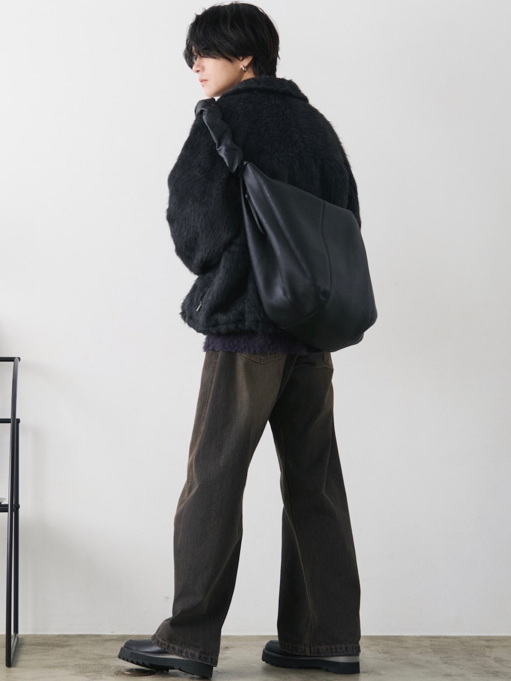 グレー系のブルゾン、ブラウン系のニット/セーター、ブラック系のデニムパンツを着用したメンズの秋コーディネートの3枚目の写真