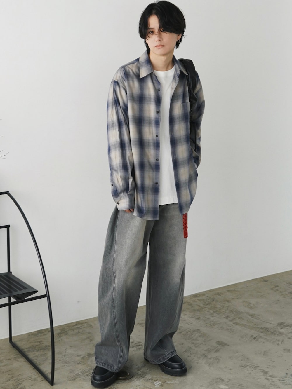 ブラック系のダウンジャケット/コート、ブルー系のシャツ/ブラウス、グレー系のデニムパンツを着用したメンズの秋コーディネートの2枚目の写真