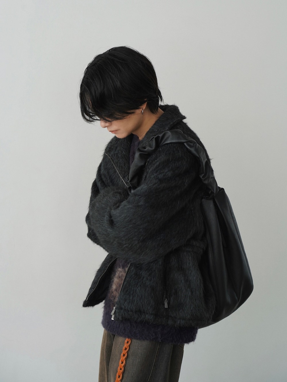 グレー系のブルゾン、ブラウン系のニット/セーター、ブラック系のデニムパンツを着用したメンズの秋コーディネートの4枚目の写真