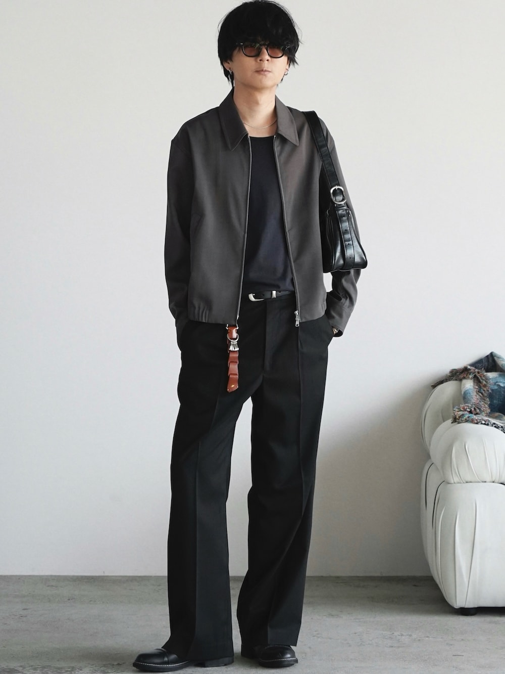 グレー系のブルゾン、ブラック系のスラックス、ブラック系のドレスシューズを着用したメンズの春コーディネートの2枚目の写真