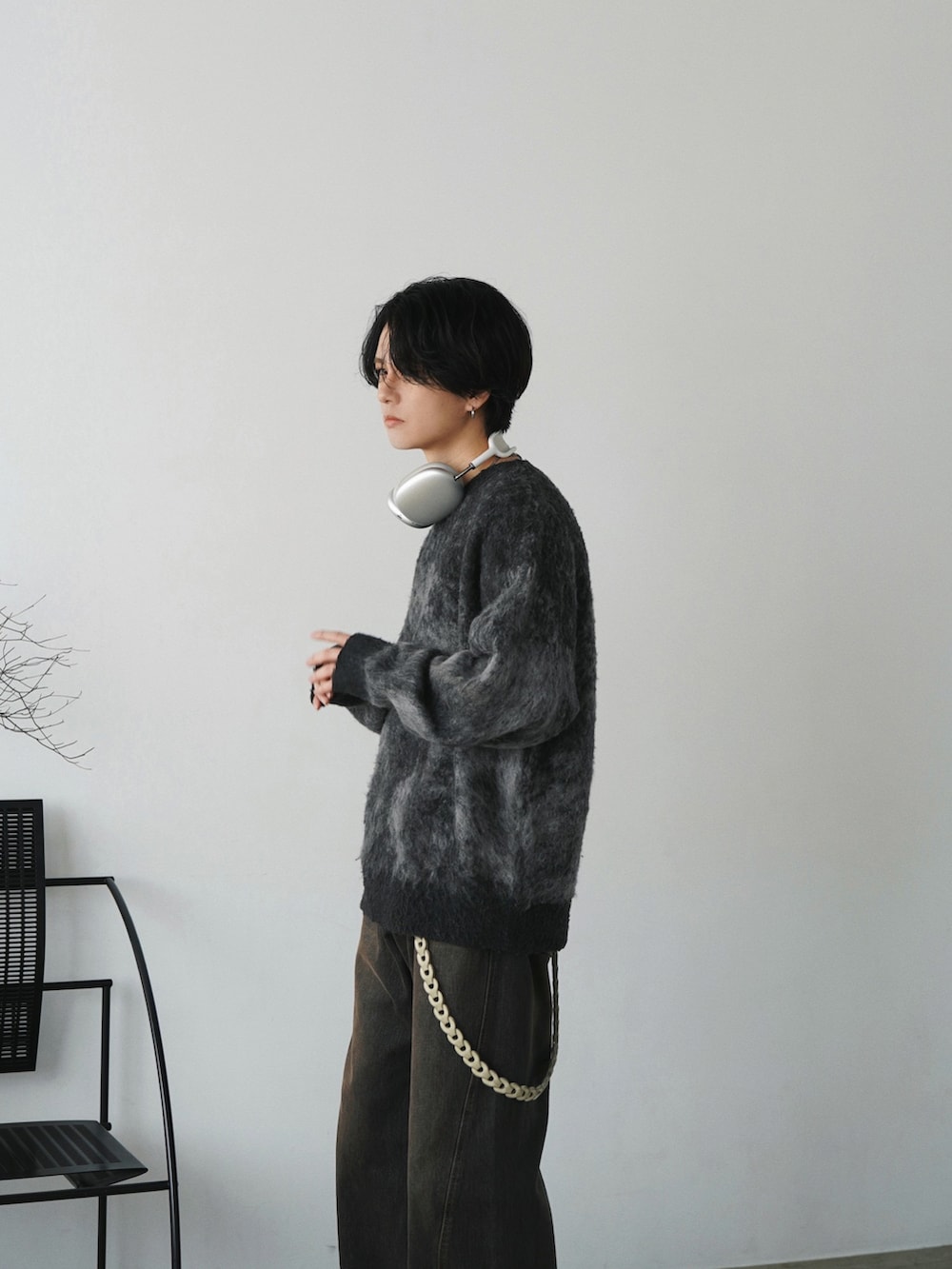 ブラウン系のダウンジャケット/コート、グレー系のニット/セーター、ブラック系のデニムパンツを着用したメンズの秋コーディネートの4枚目の写真