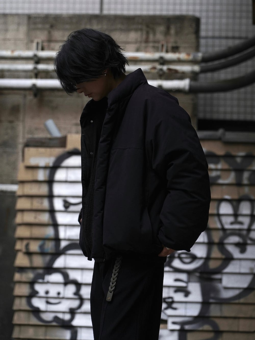 ブラック系のダウンジャケット/コート、ブラック系のTシャツ/カットソー、ブラック系のその他パンツを着用したメンズの秋コーディネートの2枚目の写真