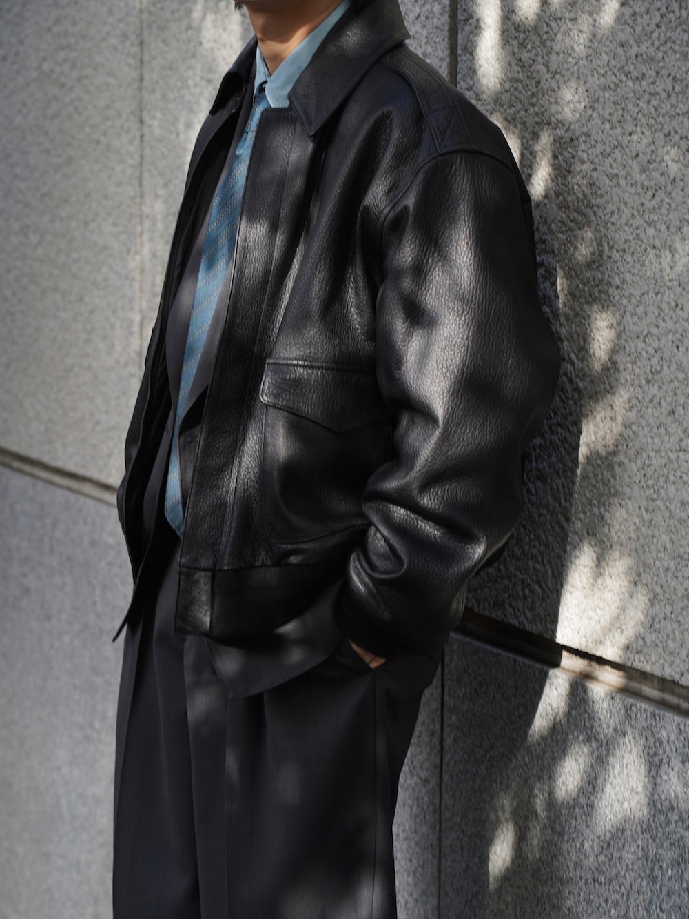 グレー系のテーラードジャケット、グレー系のスラックス、シルバー系のピアス(両耳用)を着用したメンズの冬コーディネートの5枚目の写真