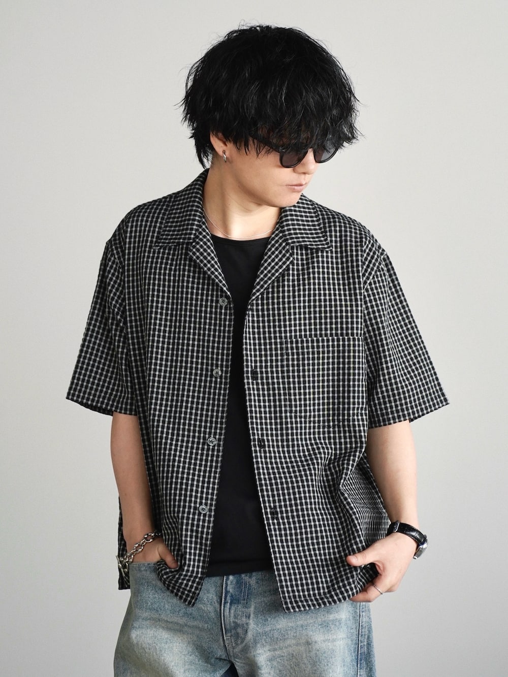 ブラック系のシャツ/ブラウス、ブラック系のタンクトップ、ブルー系のデニムパンツを着用したメンズの夏コーディネートの3枚目の写真