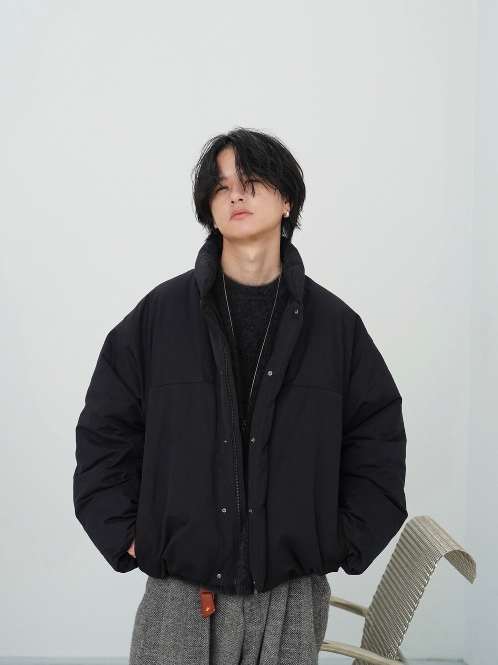 ブラック系のダウンジャケット/コート、ブラック系のニット/セーター、グレー系のその他パンツを着用したメンズの秋コーディネートの4枚目の写真