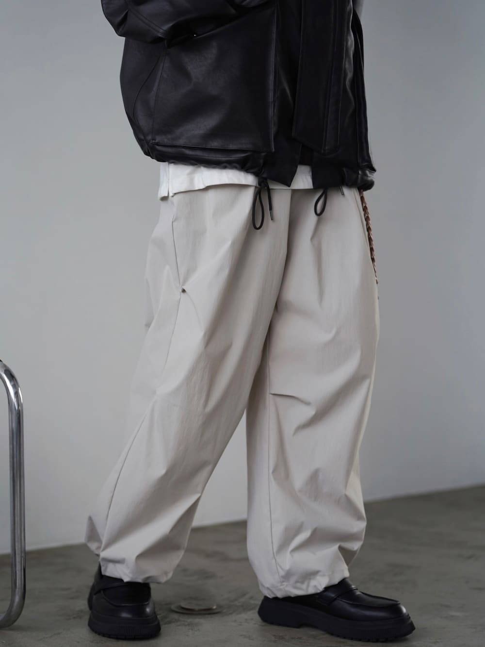 ブラウン系のブルゾン、ブラック系のTシャツ/カットソー、ホワイト系のタンクトップを着用したメンズの秋コーディネートの3枚目の写真