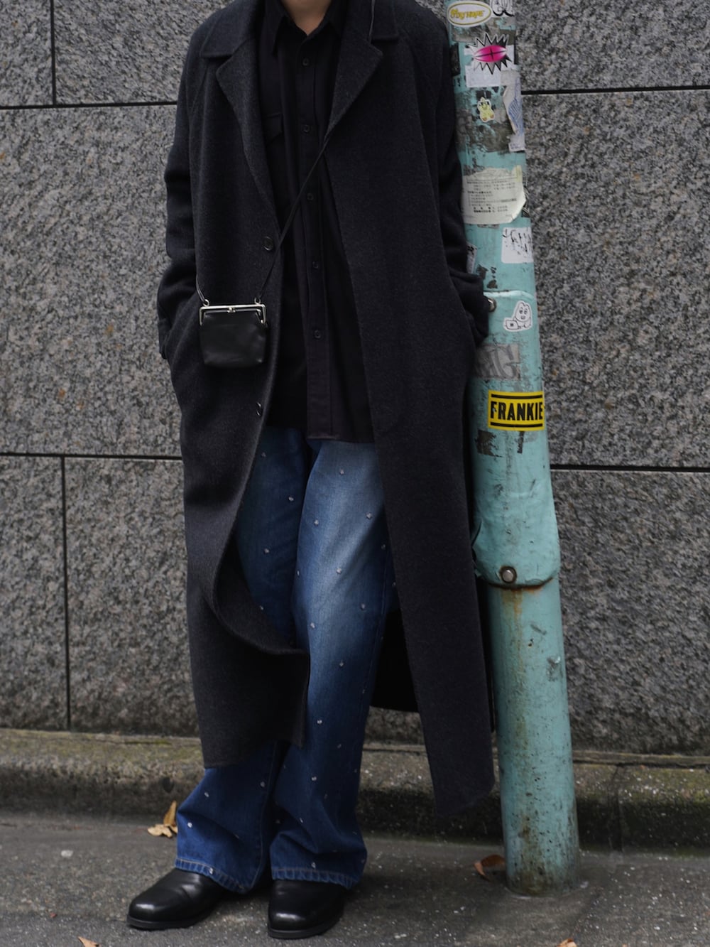 ブラック系のチェスターコート、ブラウン系のシャツ/ブラウス、ブルー系のパンツを着用したメンズの冬コーディネートの3枚目の写真