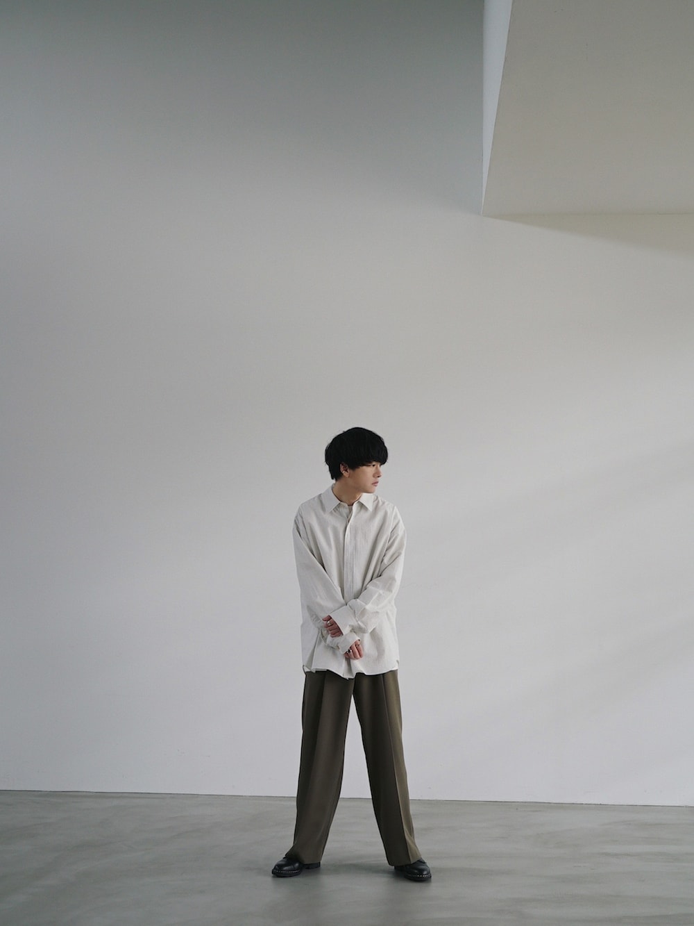 ホワイト系のシャツ/ブラウス、ホワイト系のTシャツ/カットソー、ベージュ系のスラックスを着用したメンズの秋コーディネートの3枚目の写真