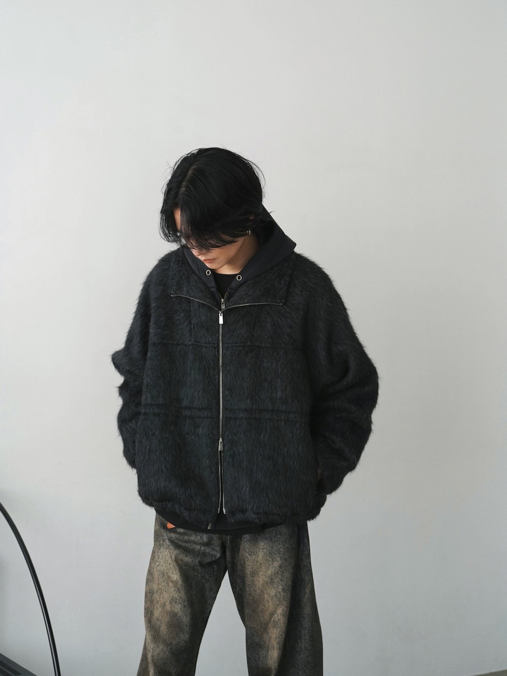 グレー系のブルゾン、ブラック系のパーカー、ブラック系のTシャツ/カットソーを着用したメンズの秋コーディネートの5枚目の写真