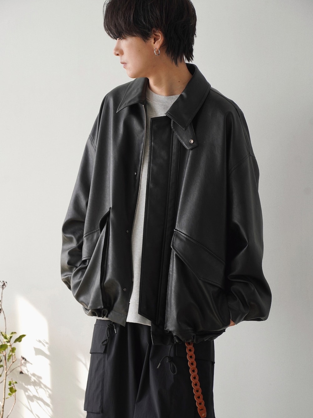 ブラック系のブルゾン、グレー系のスウェット、ブラック系のカーゴパンツを着用したメンズの春コーディネートの3枚目の写真