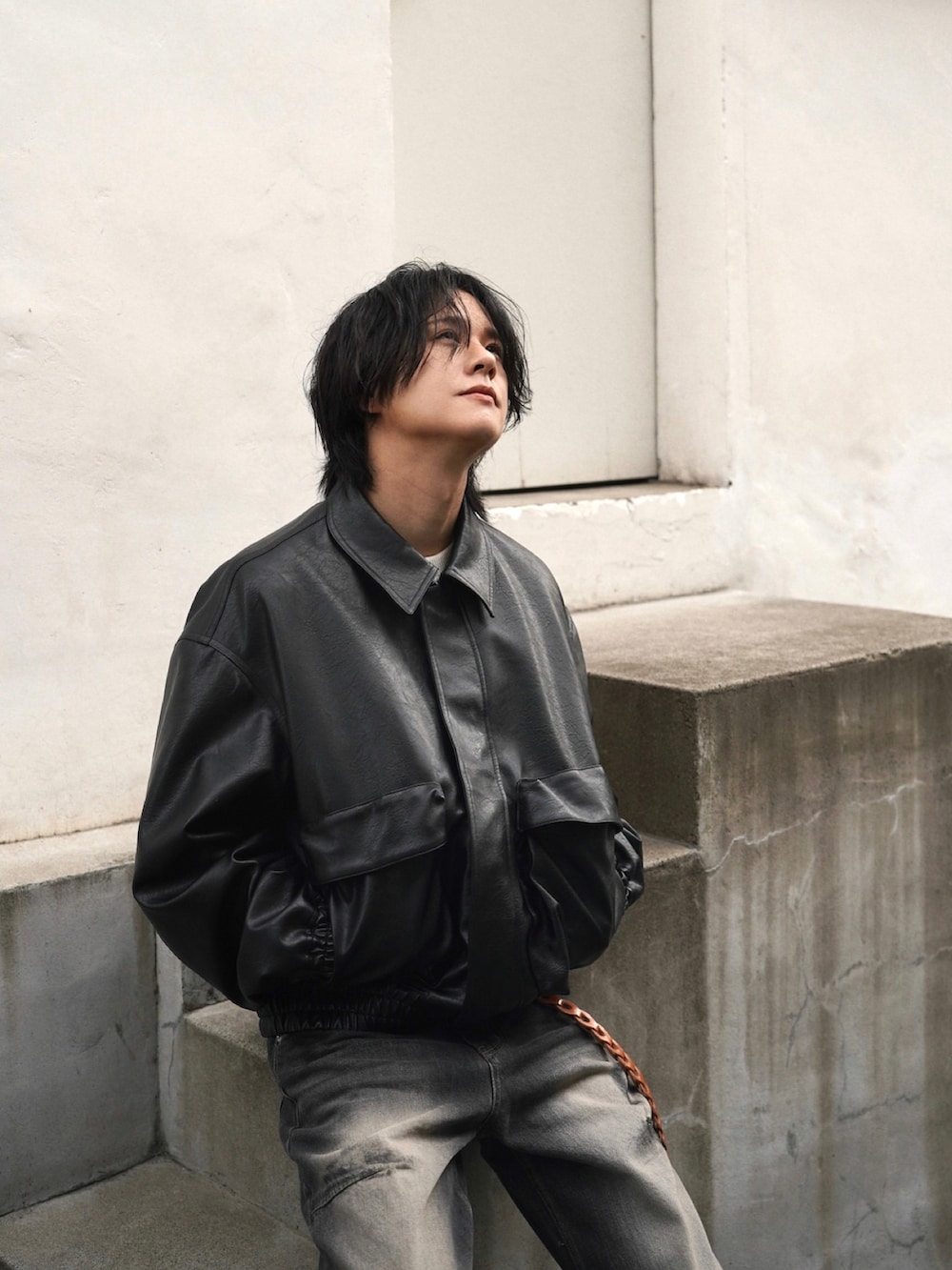 ブラック系のスニーカー、ホワイト系のニット/セーター、ブラック系のブルゾンを着用したメンズの秋コーディネートの3枚目の写真