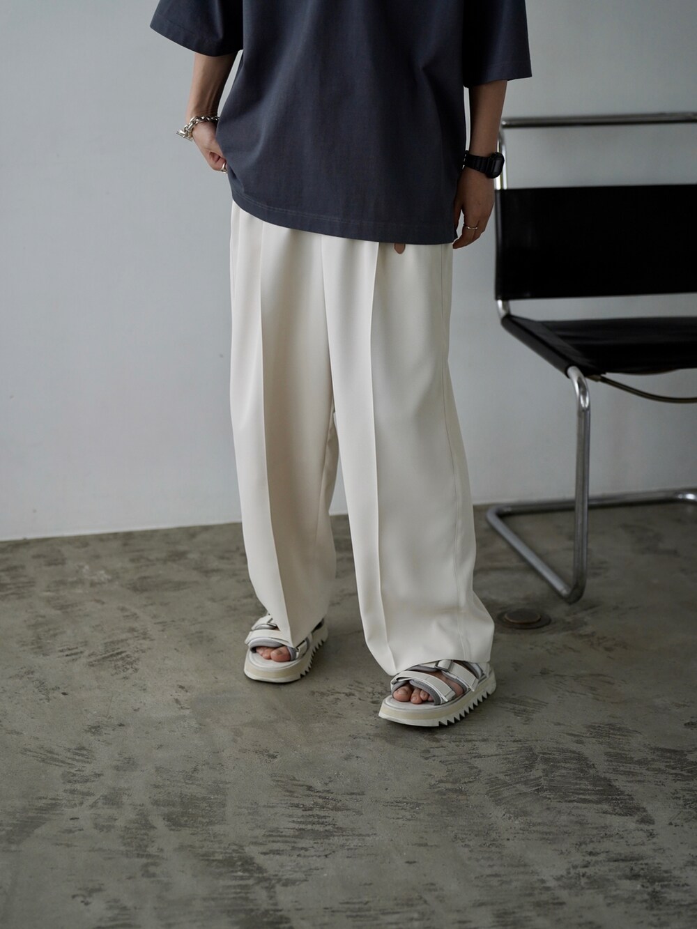 ブルー系のTシャツ/カットソー、ホワイト系のスラックス、ホワイト系のサンダルを着用したメンズの夏コーディネートの3枚目の写真