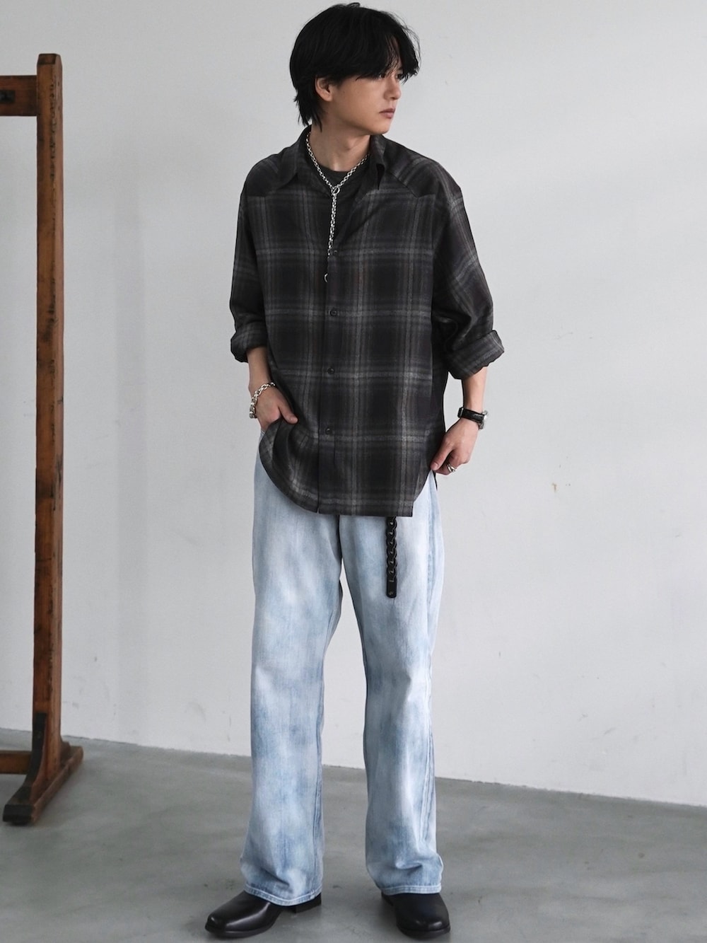 グレー系のチェスターコート、ブラック系のブーツ、ブラウン系のシャツ/ブラウスを着用したメンズの春コーディネートの2枚目の写真