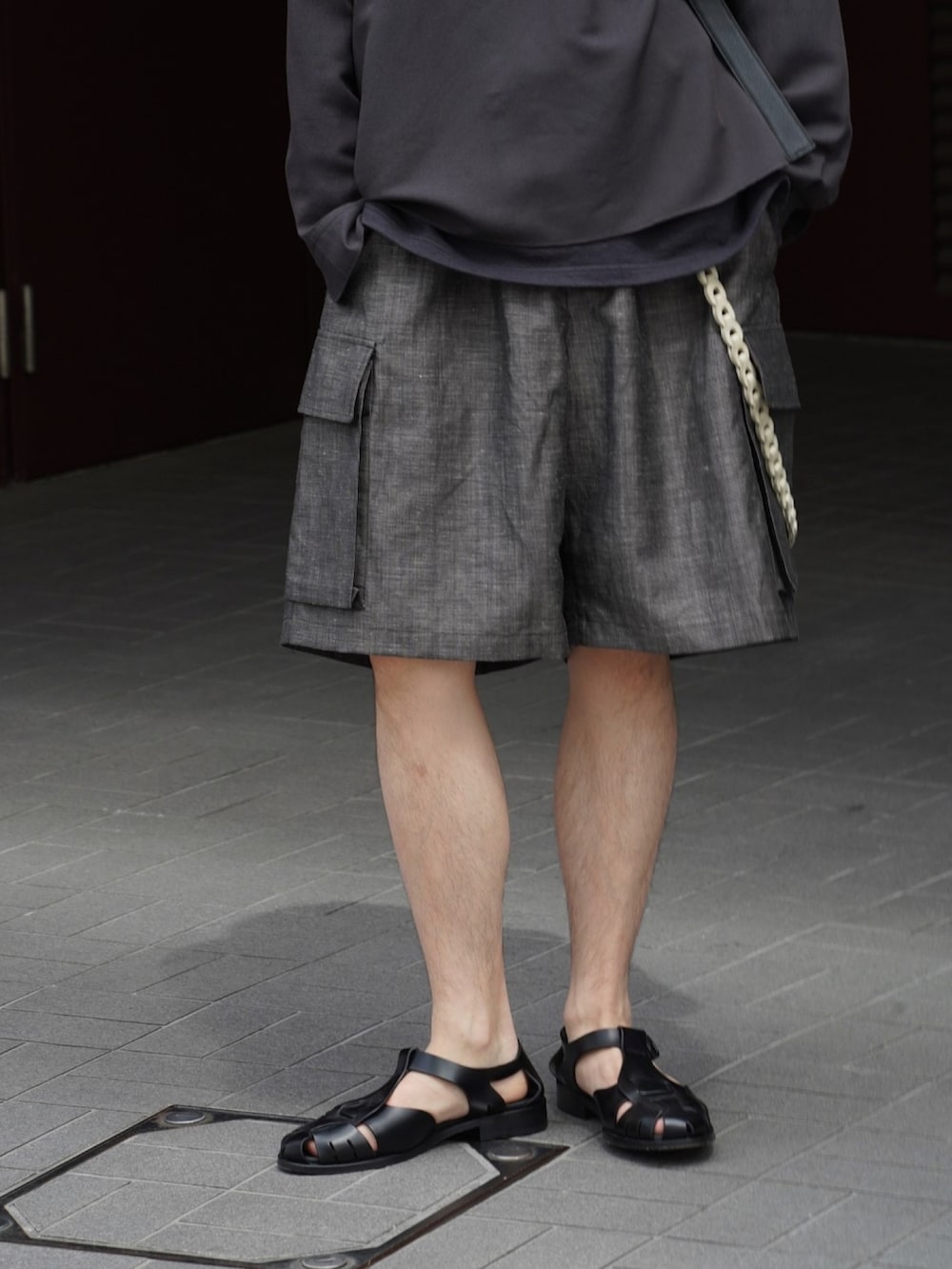 ブラック系のシャツ/ブラウス、ブラック系のタンクトップ、ブラウン系のカーゴパンツを着用したメンズの春コーディネートの5枚目の写真