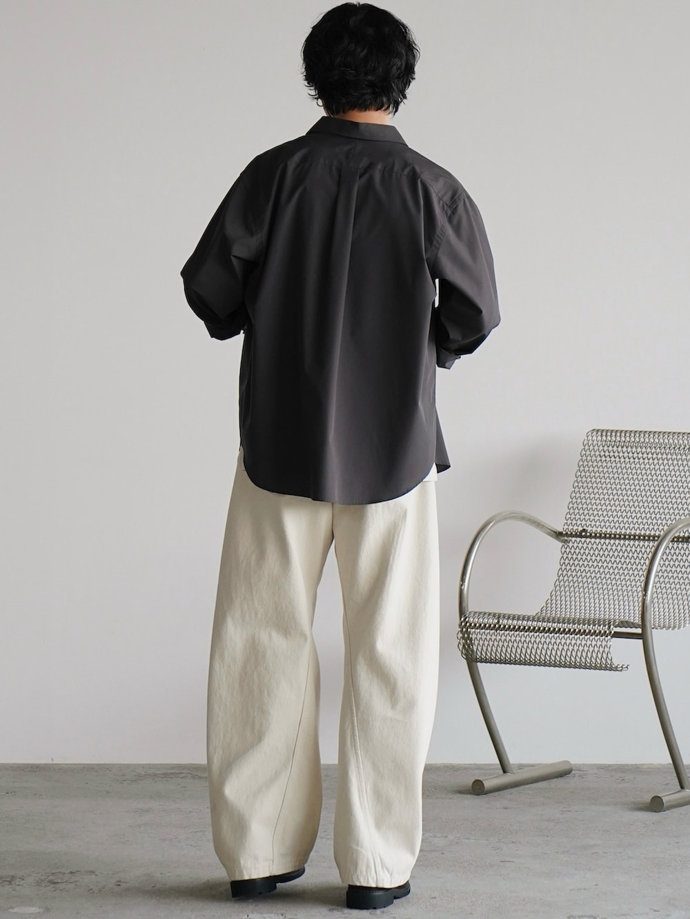 グレー系のシャツ/ブラウス、グレー系のタンクトップ、ホワイト系のデニムパンツを着用したメンズの秋コーディネートの4枚目の写真