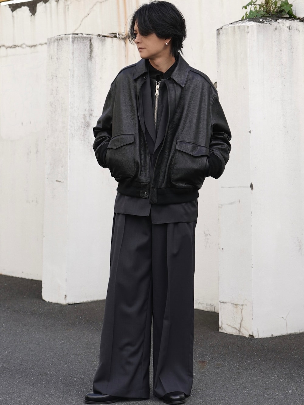 ブラック系のブルゾン、グレー系のテーラードジャケット、グレー系のスラックスを着用したメンズの冬コーディネートの2枚目の写真