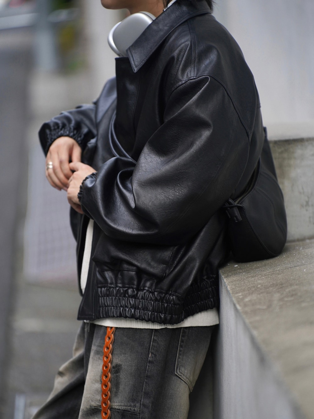 ブラック系のスニーカー、ホワイト系のニット/セーター、ブラック系のブルゾンを着用したメンズの秋コーディネートの4枚目の写真