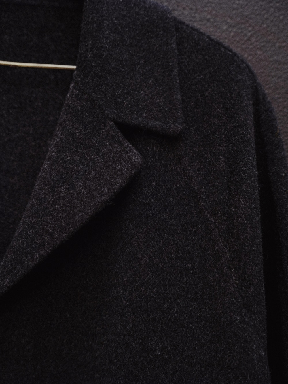 ブラック系のチェスターコート、ブラック系のテーラードジャケット、グリーン系のニット/セーターを着用したメンズの秋コーディネートの5枚目の写真