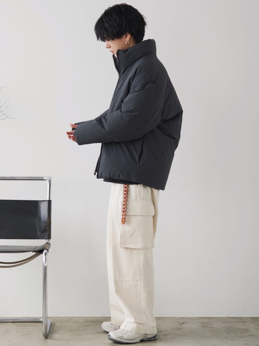 グレー系のダウンジャケット/コート、グレー系のニット/セーター、ホワイト系のカーゴパンツを着用したメンズの冬コーディネートの2枚目の写真