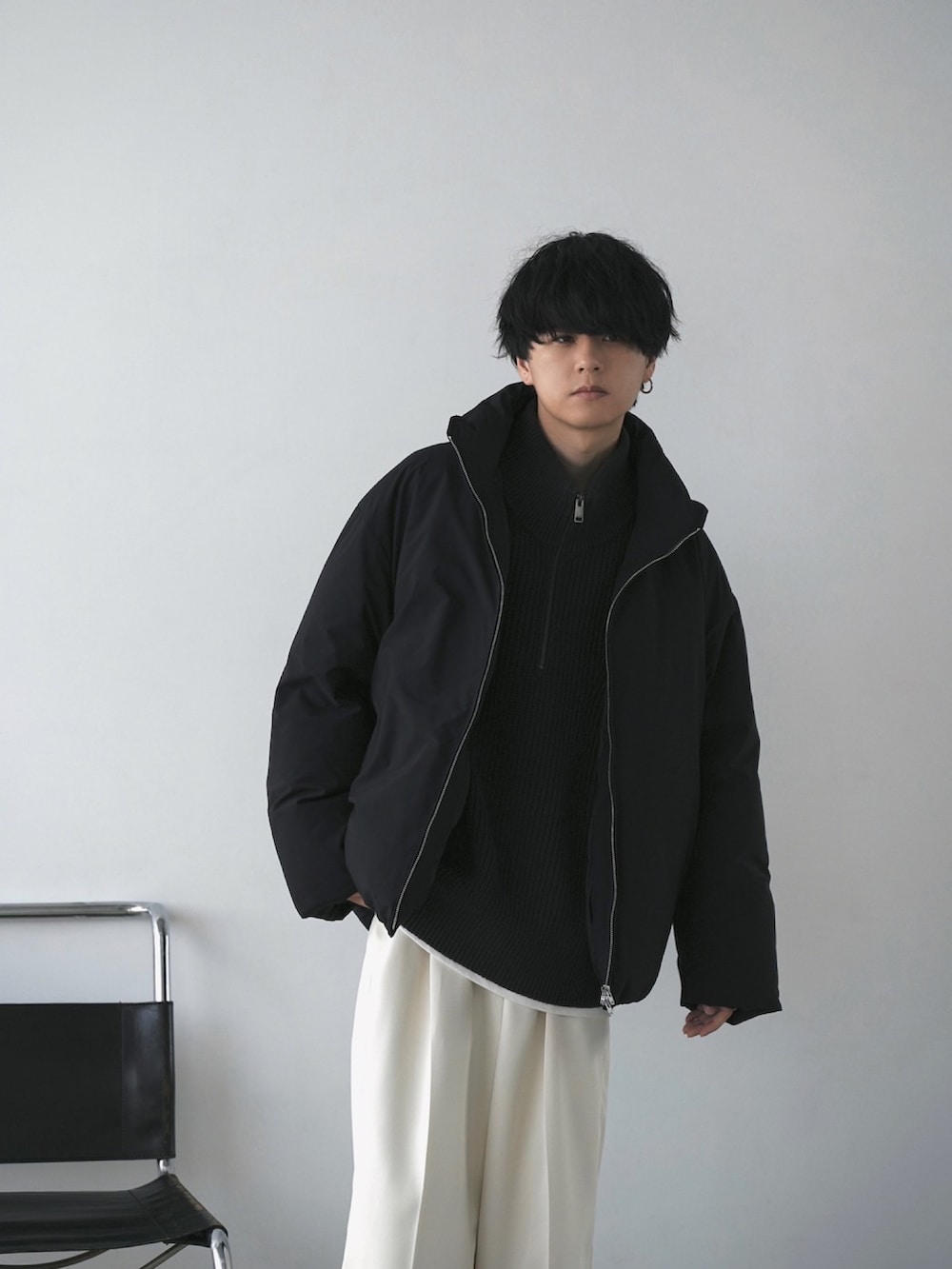 ブラック系のダウンジャケット/コート、グレー系のニット/セーター、ホワイト系のタンクトップを着用したメンズの秋コーディネートの3枚目の写真