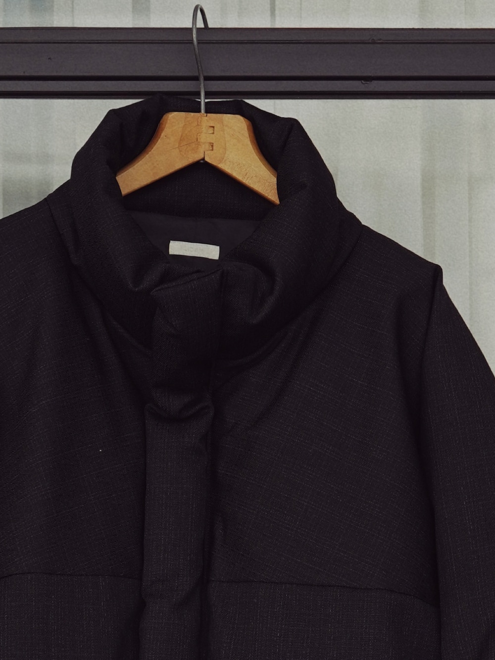 ブラック系のダウンジャケット/コート、グリーン系のニット/セーター、グレー系のスラックスを着用したメンズの秋コーディネートの3枚目の写真