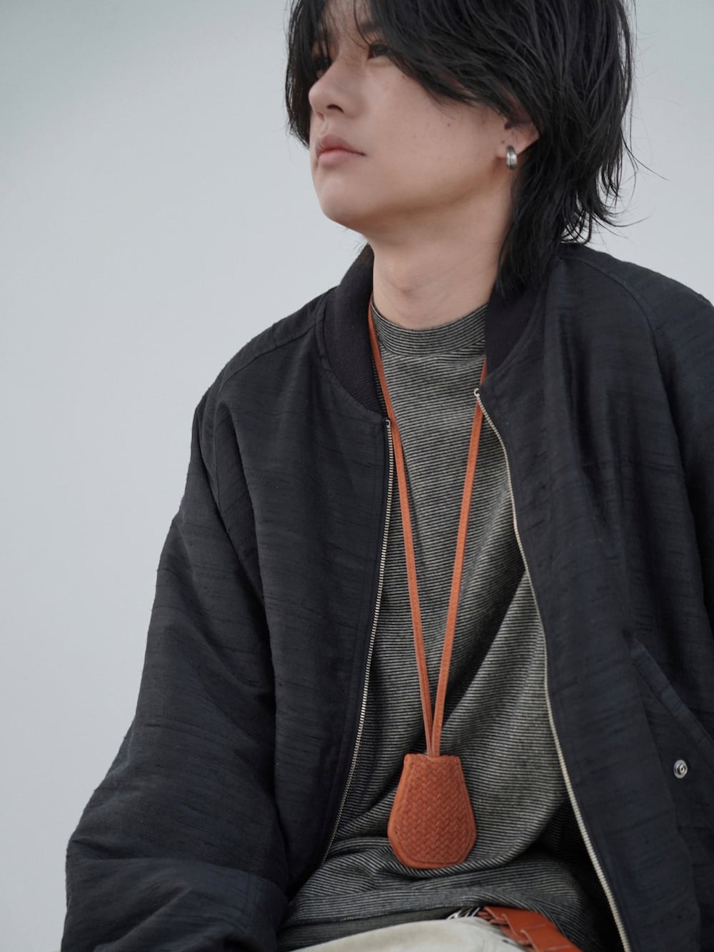 ブラック系のMA-1、ベージュ系のカーゴパンツ、イエロー系のTシャツ/カットソーを着用したメンズの夏コーディネートの4枚目の写真