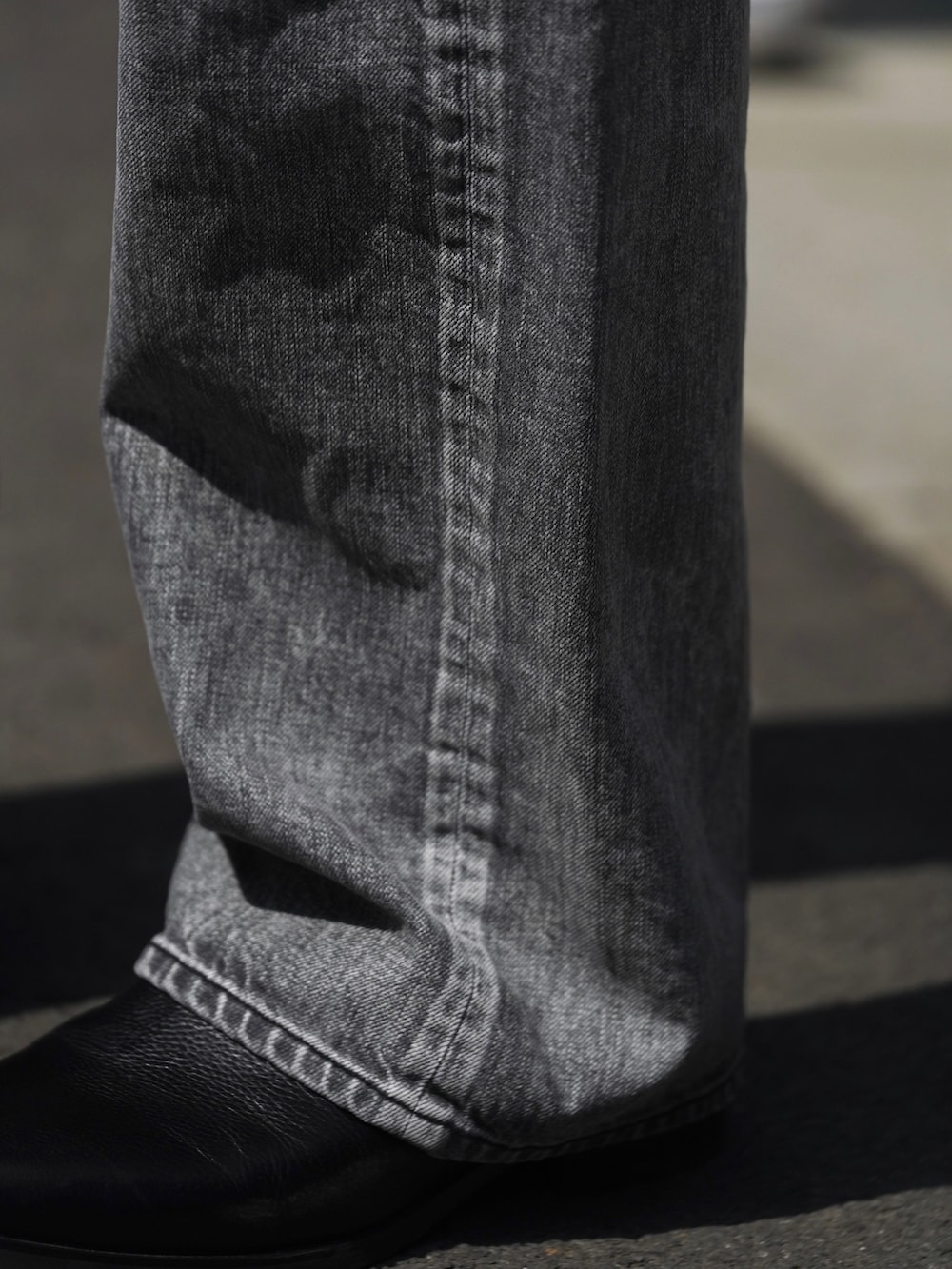 ブラック系のジャケット/アウター、グレー系のTシャツ/カットソー、グレー系のデニムパンツを着用したメンズの春コーディネートの4枚目の写真