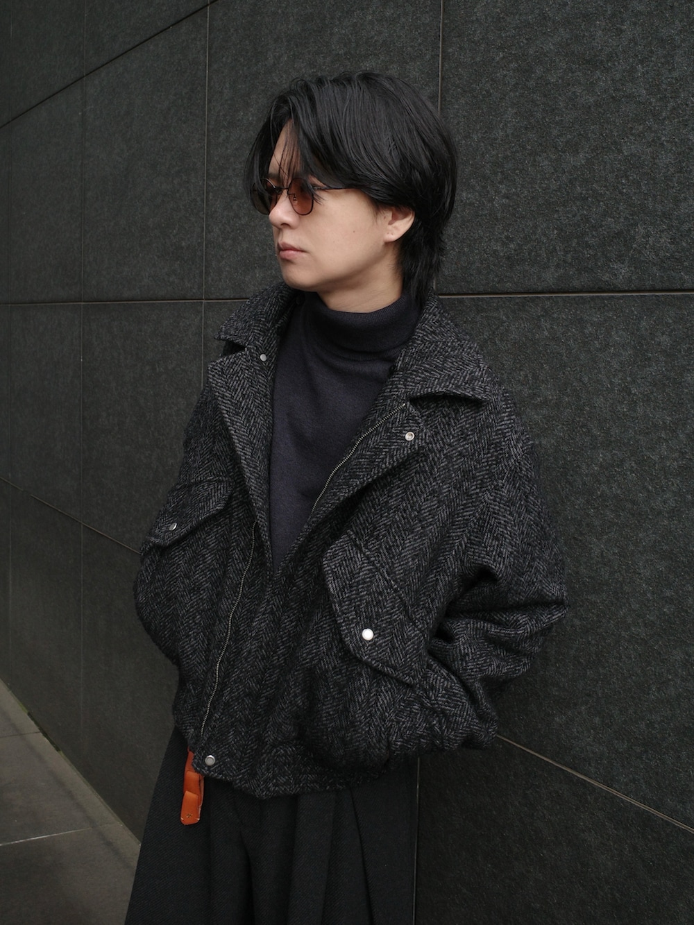 グレー系のニット/セーター、ブラック系のジャケット/アウター、グレー系のパンツを着用したメンズの秋コーディネートの2枚目の写真