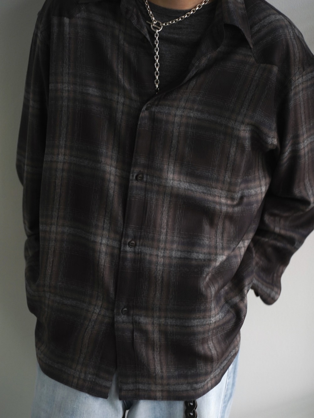 グレー系のチェスターコート、ブラック系のブーツ、ブラウン系のシャツ/ブラウスを着用したメンズの春コーディネートの4枚目の写真