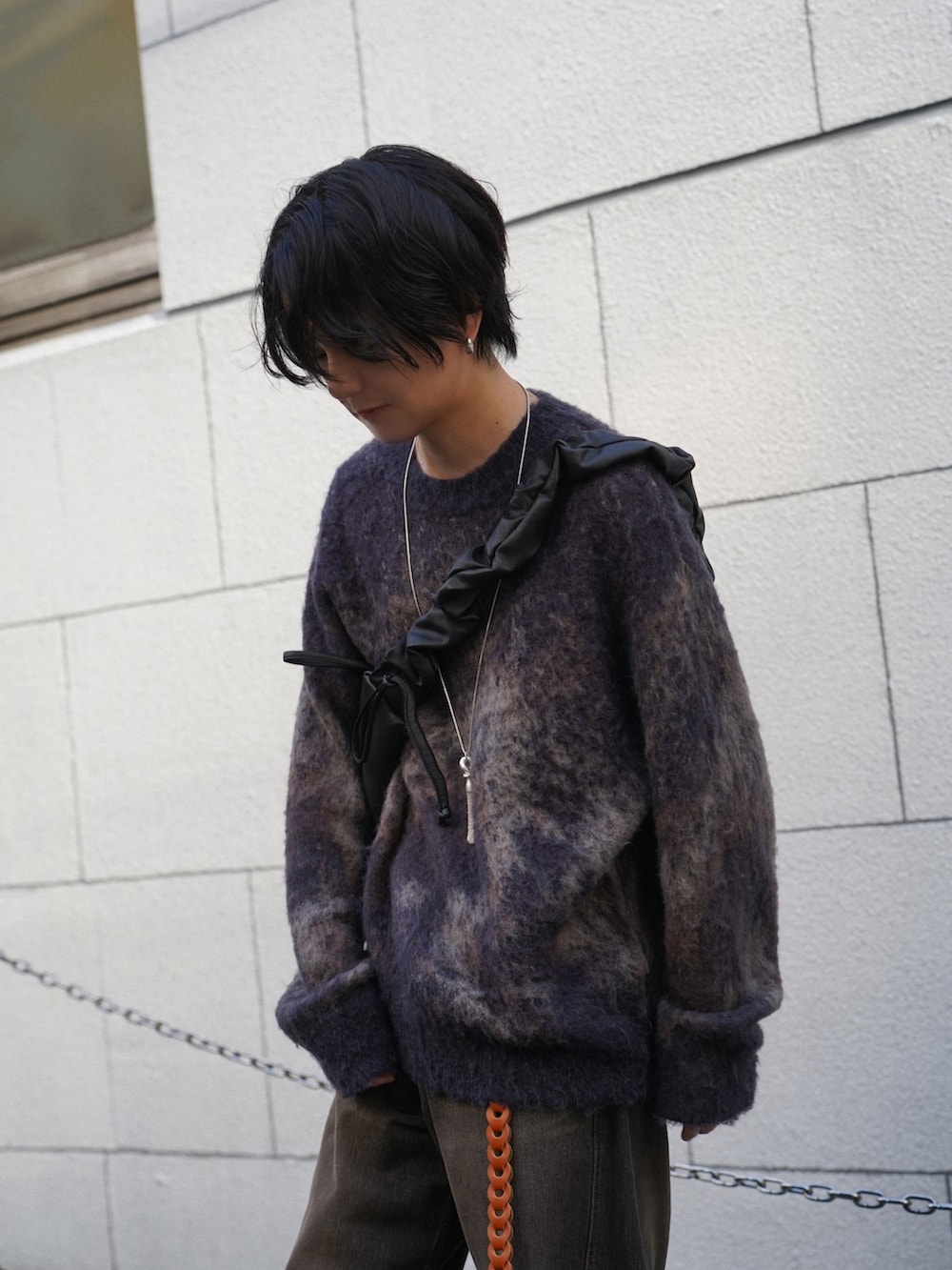 ブラウン系のニット/セーター、ブラック系のデニムパンツ、ブラック系のショルダーバッグを着用したメンズの秋コーディネートの2枚目の写真