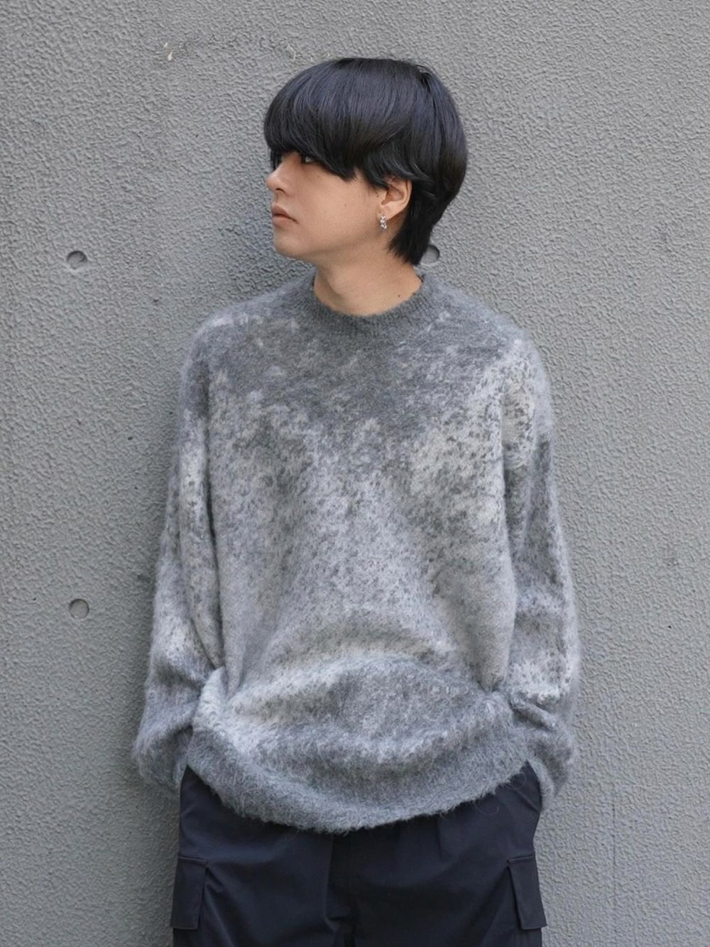 グレー系のニット/セーター、ブラック系のブーツ、シルバー系のピアス(片耳用)を着用したメンズの冬コーディネートの2枚目の写真