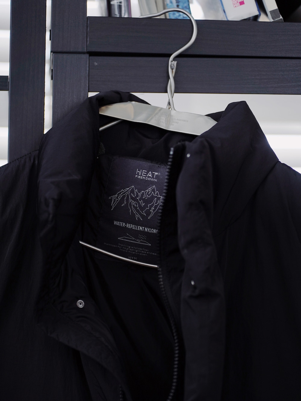 ブラック系のダウンジャケット/コート、グレー系のパーカー、グレー系のカーゴパンツを着用したメンズの冬コーディネートの2枚目の写真