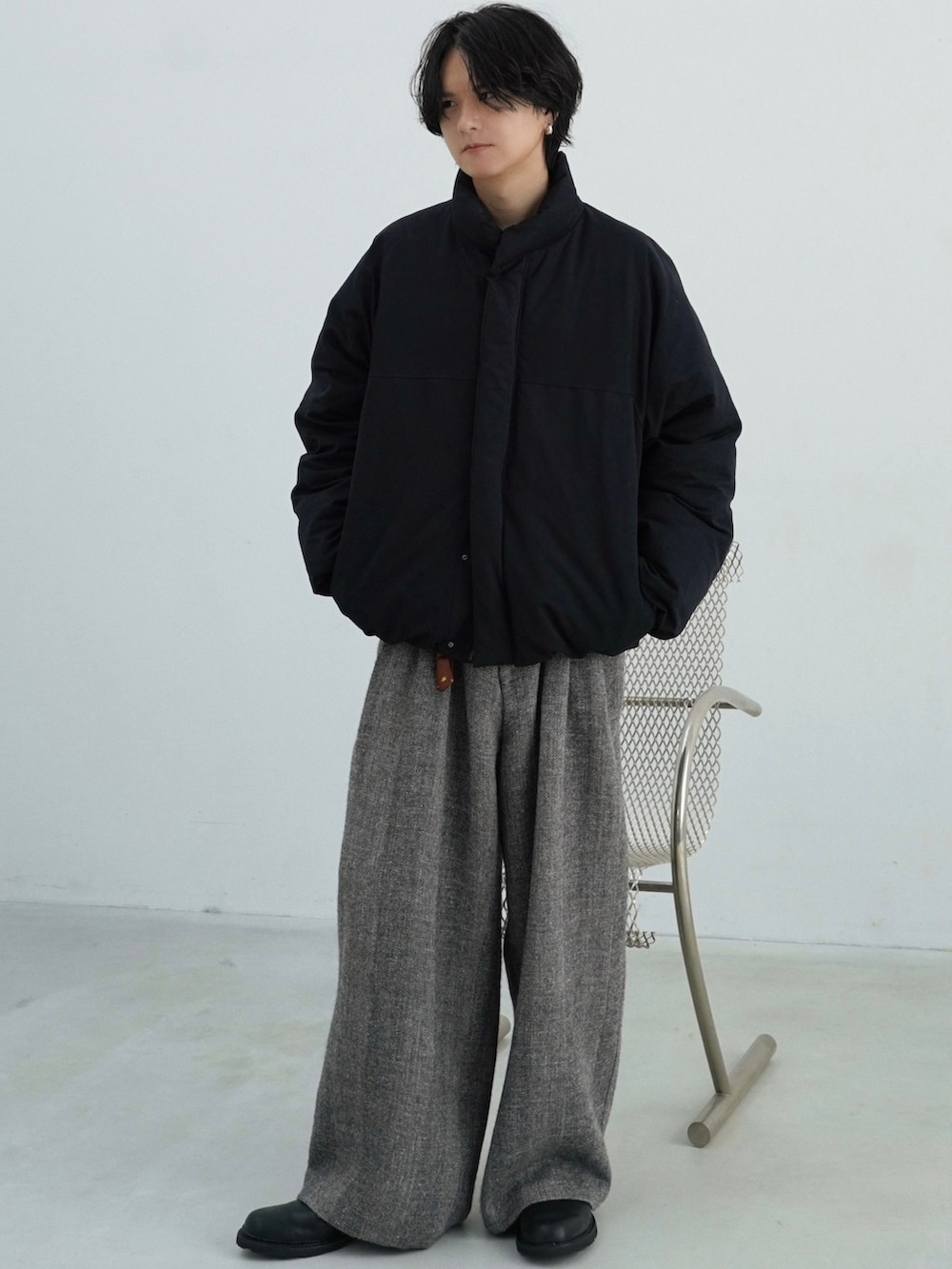 ブラック系のダウンジャケット/コート、ブラック系のニット/セーター、グレー系のその他パンツを着用したメンズの秋コーディネートの2枚目の写真