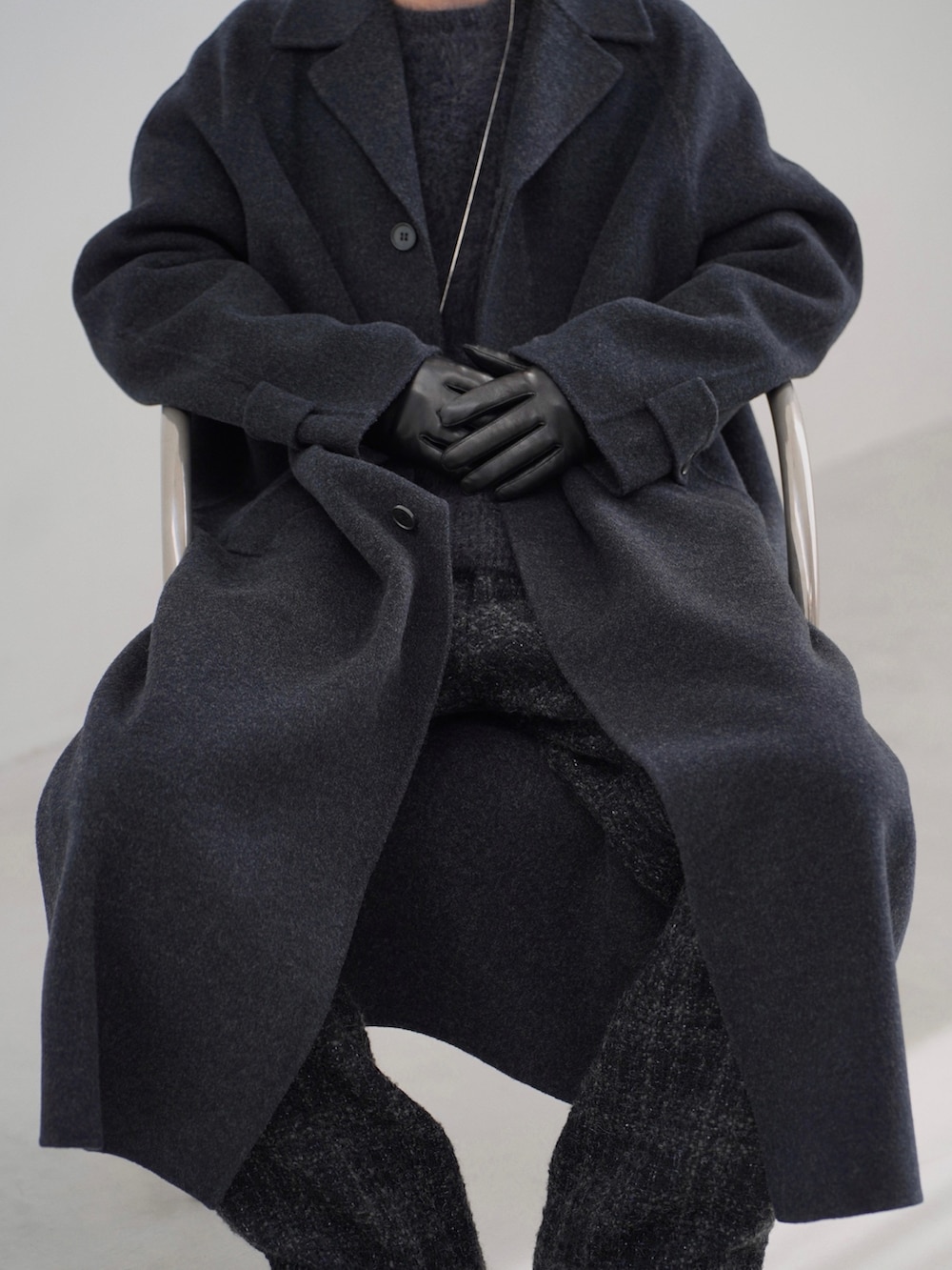 ブラック系のチェスターコート、ブラック系のニット/セーター、ブラック系のその他パンツを着用したメンズの秋コーディネートの4枚目の写真