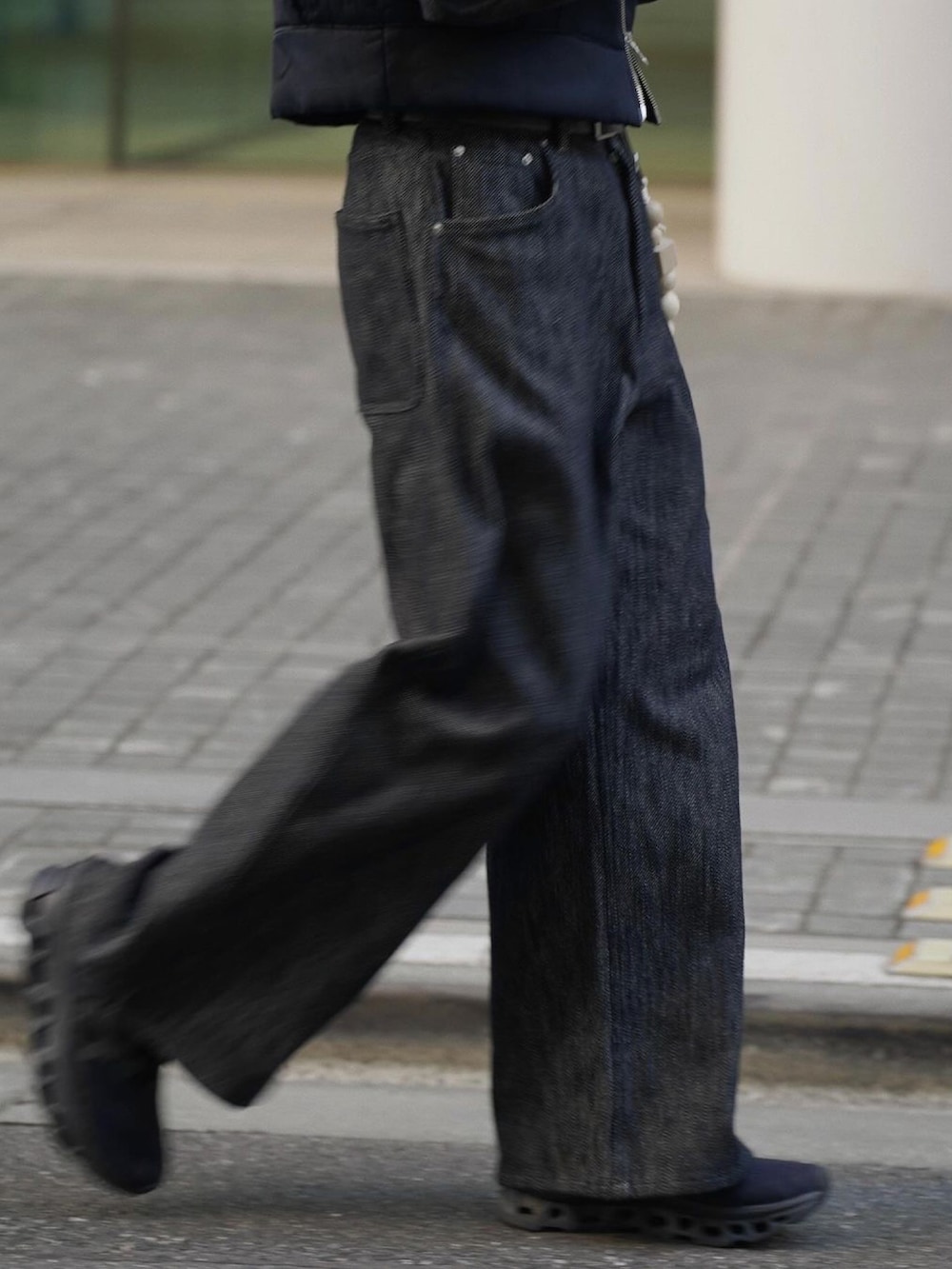 ブラック系のベスト、グレー系のニット/セーター、ブラック系のデニムパンツを着用したメンズの冬コーディネートの4枚目の写真