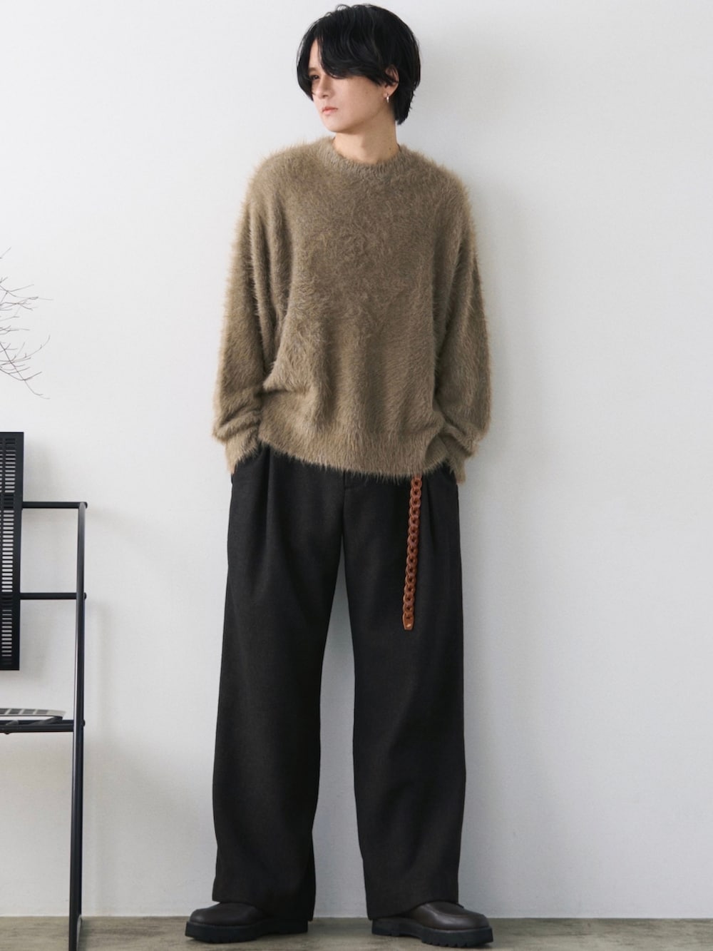 グリーン系のダウンジャケット/コート、グリーン系のニット/セーター、グレー系のスラックスを着用したメンズの秋コーディネートの4枚目の写真