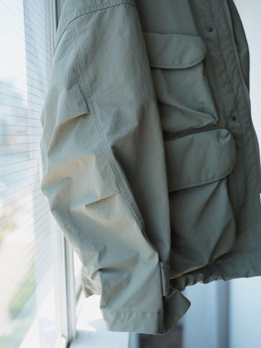 グリーン系のブルゾン、ブルー系のシャツ/ブラウス、グレー系のTシャツ/カットソーを着用したメンズの夏コーディネートの4枚目の写真