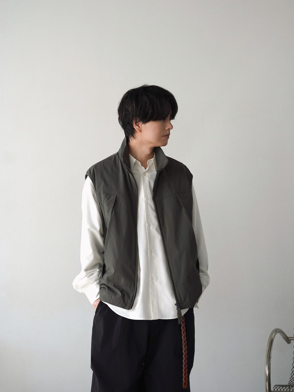 グレー系のベスト、ホワイト系のシャツ/ブラウス、ブルー系のその他パンツを着用したメンズの春コーディネートの4枚目の写真