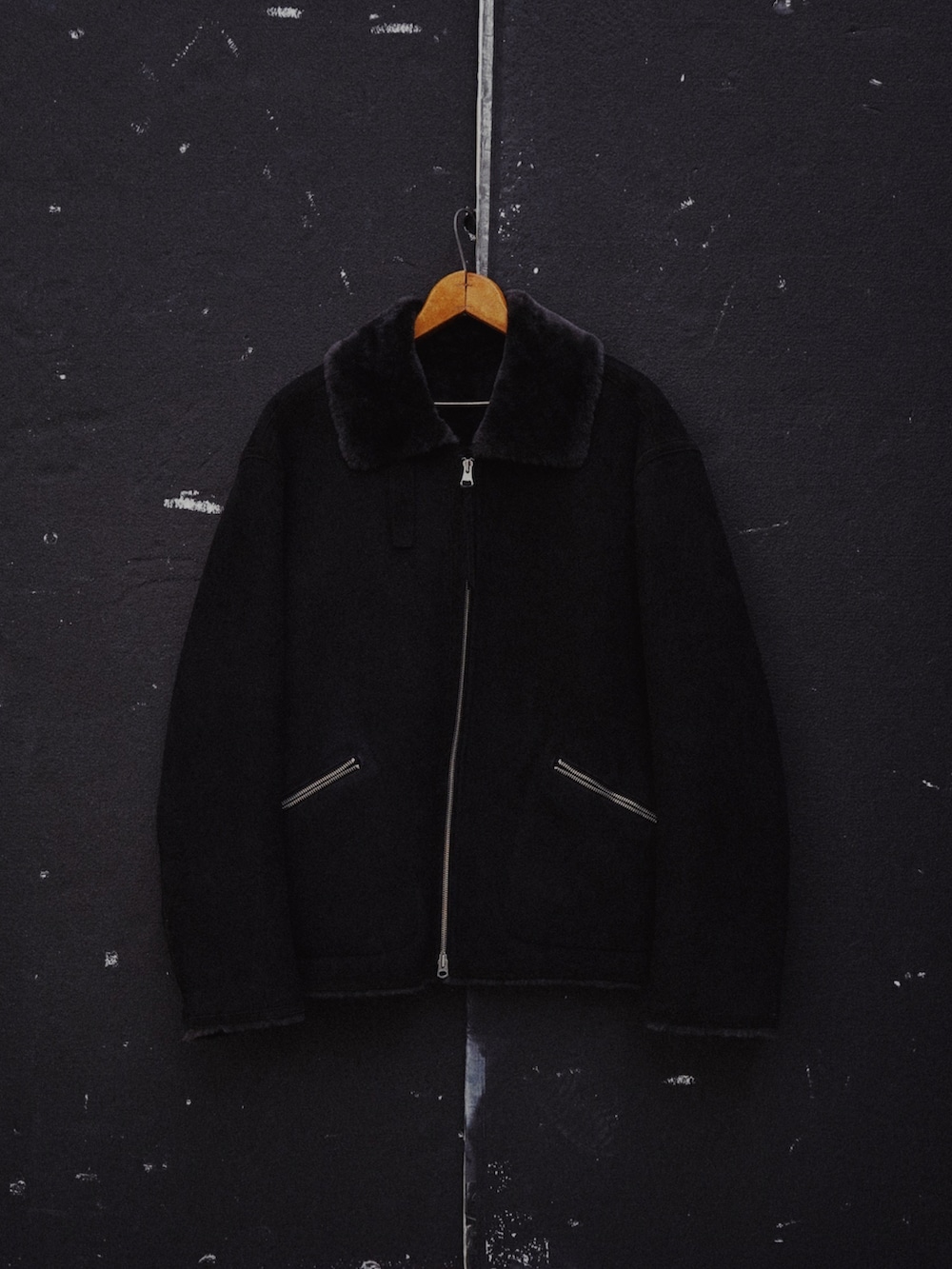 ブラック系のムートンコート、ブラック系のニット/セーター、グレー系のその他パンツを着用したメンズの秋コーディネートの5枚目の写真