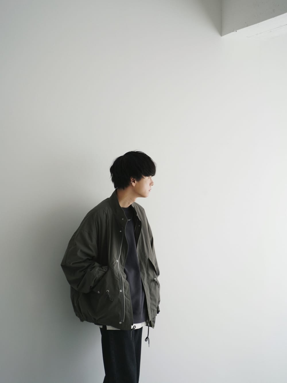 グリーン系のモッズコート、グリーン系のスウェット、ホワイト系のタンクトップを着用したメンズの秋コーディネートの3枚目の写真