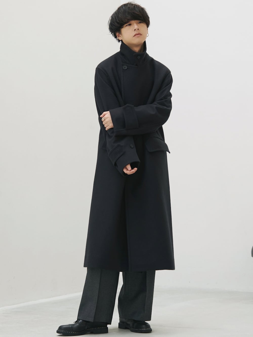 グリーン系のチェスターコート、グレー系のスラックス、ブラック系のドレスシューズを着用したメンズの秋コーディネートの2枚目の写真