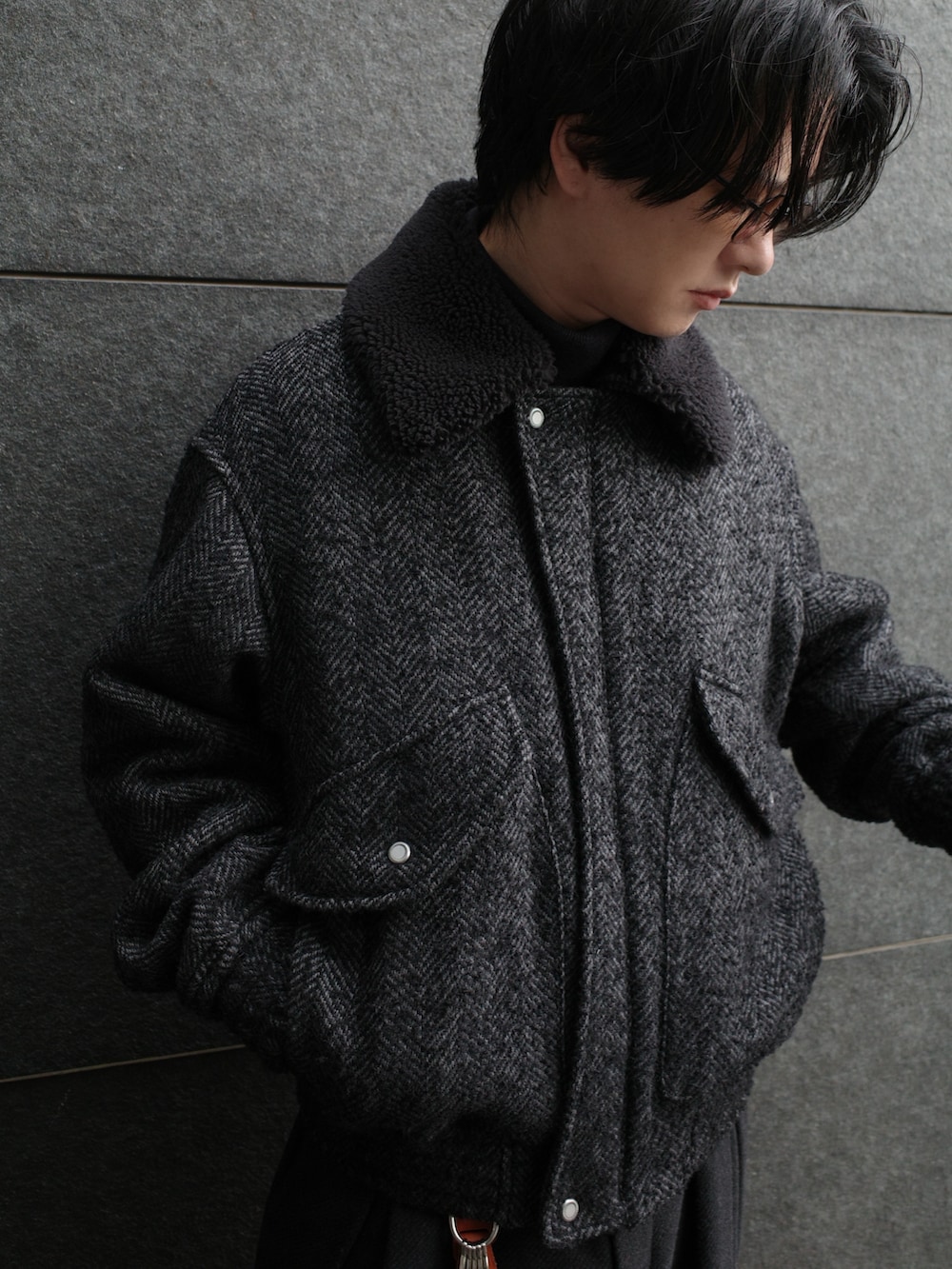 グレー系のニット/セーター、ブラック系のジャケット/アウター、グレー系のパンツを着用したメンズの秋コーディネートの3枚目の写真